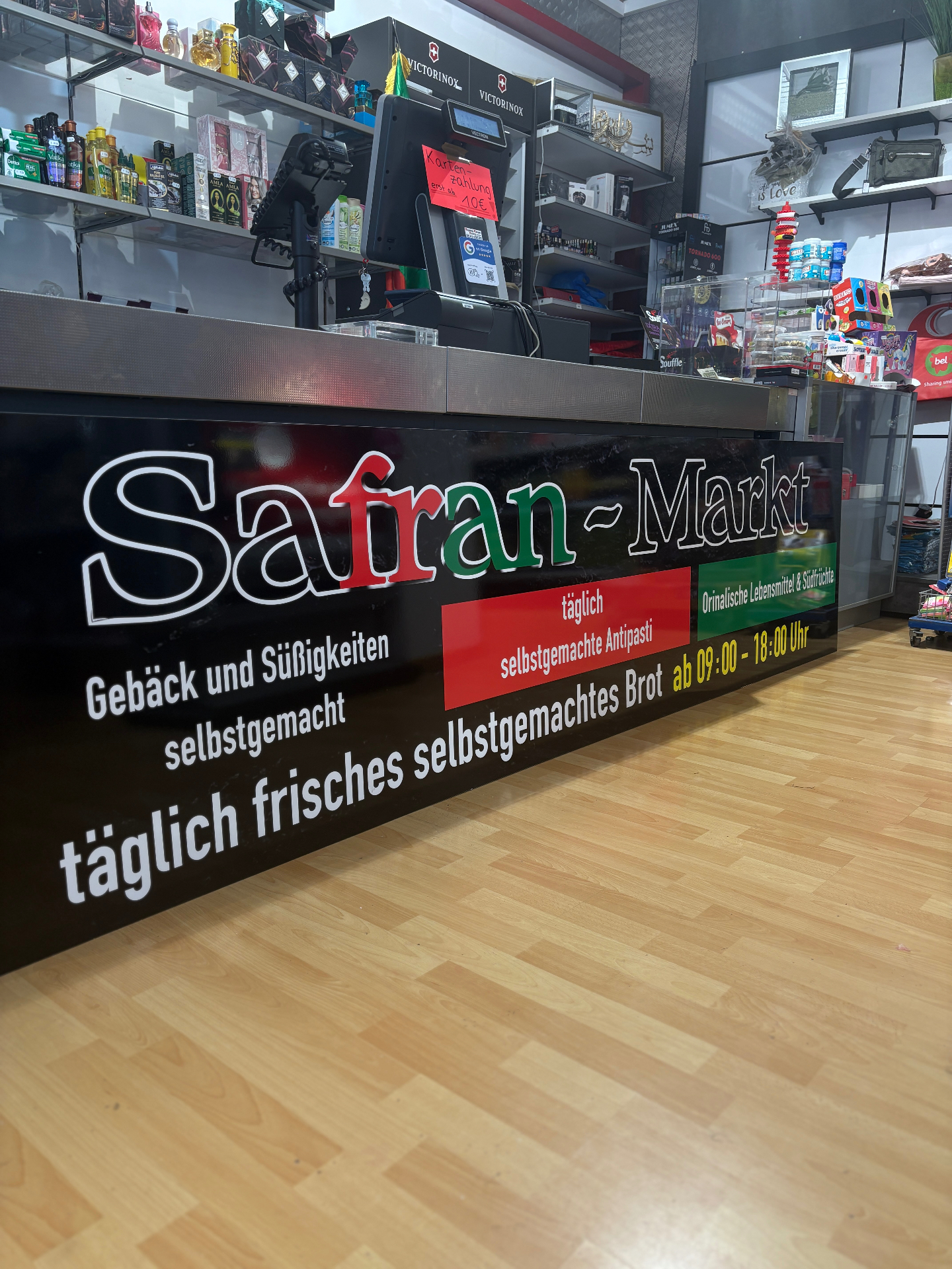 Kassentheke im Safran-Markt mit Logo